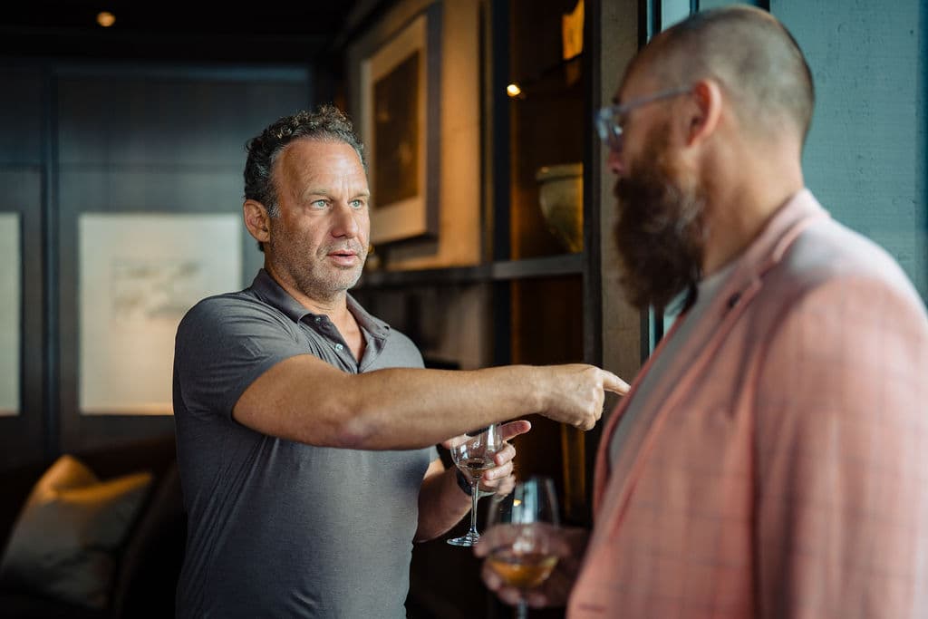 Jonathan Raymond making a point to a guest before dinner